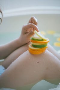 Midsection of woman holding fruit