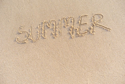 High angle view of text on sand at beach