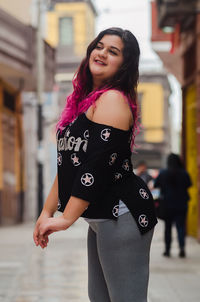 Portrait of beautiful woman standing in city