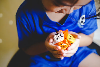 Midsection of girl holding halloween candies