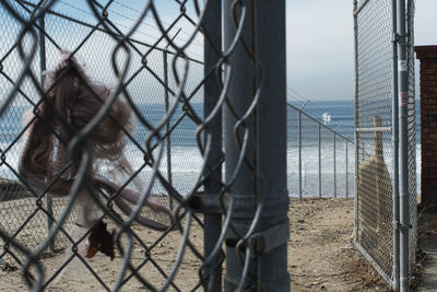 Chainlink fence by building against sky