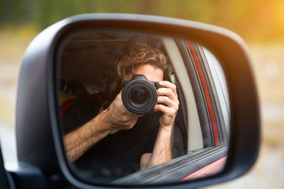 Portrait of man photographing through camera