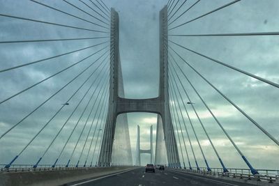 Low angle view of suspension bridge against sky