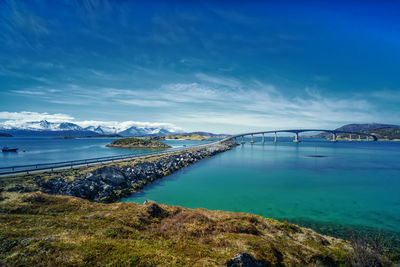 Bridge over sea against blue sky