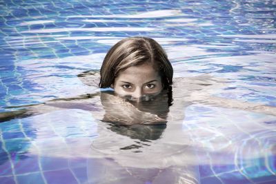 Portrait of young woman swimming in pool