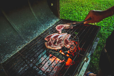 Midsection of man preparing food on barbecue grill