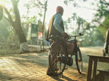 Rear view of man riding bicycle on street