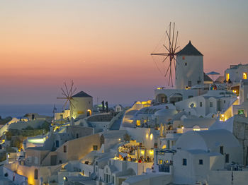 Traditional building by sea against sky during sunset