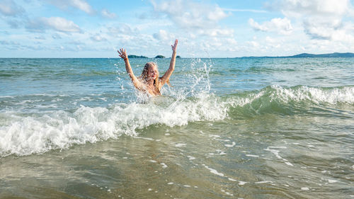 Man surfing in sea against sky