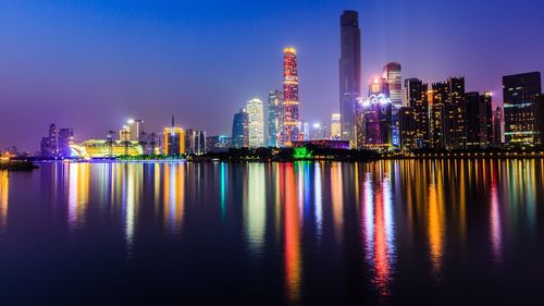 Illuminated cityscape reflecting in pearl river against sky at night