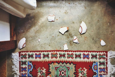 Directly above shot of broken plate by carpet at home