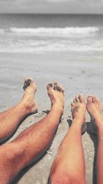 Low section of woman relaxing on beach