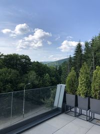 Empty road by trees in forest against sky