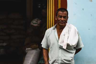 Portrait of smiling man standing against wall