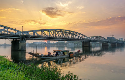 Bridge over river against sky during sunset