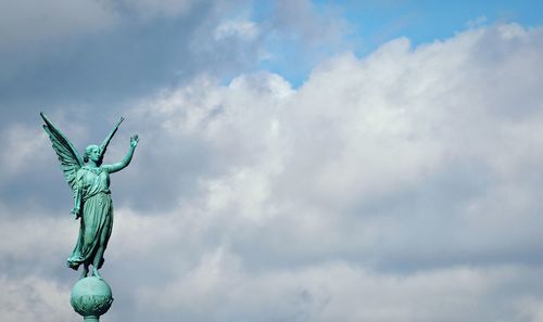 Low angle view of angel statue against sky