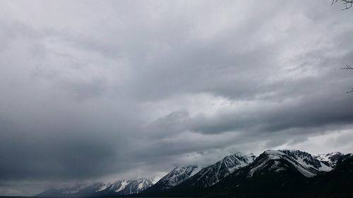 Snow covered mountains against cloudy sky