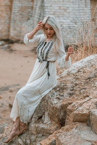 Young woman sitting on rock