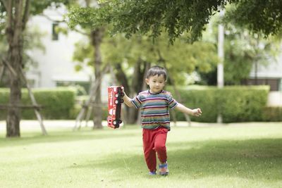 Full length of cute boy playing on field