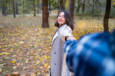 Portrait of young woman standing in forest