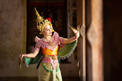 Young woman wearing traditional clothing dancing in temple