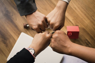 Fists of colleagues over table