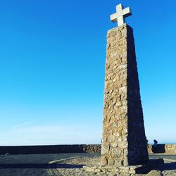 Low angle view of cross against clear blue sky