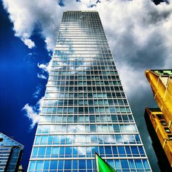Low angle view of modern building against cloudy sky