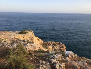 Rock formations by sea against sky