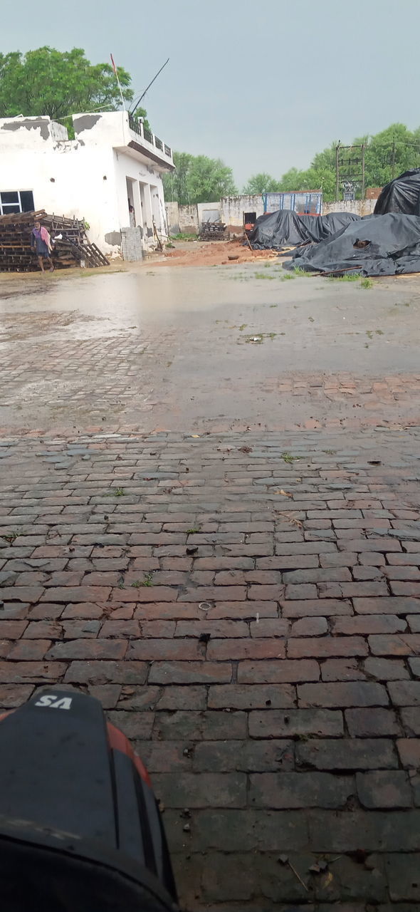 SURFACE LEVEL VIEW OF STREET BY BUILDINGS AGAINST SKY