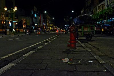 Low section of people on road in city at night