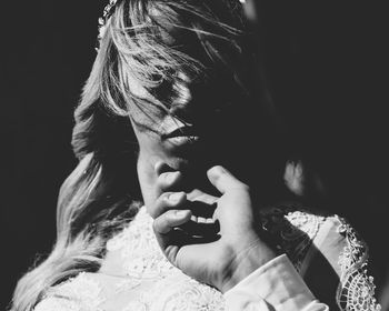 Portrait of woman holding cigarette against black background