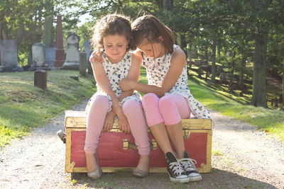 Full length of happy friends sitting outdoors