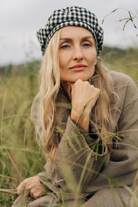 Portrait of young woman sitting on field