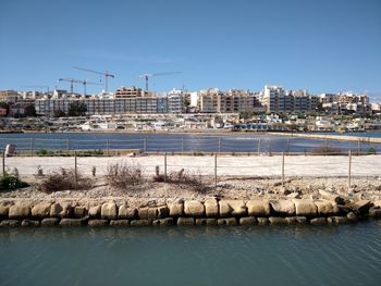 City by sea against clear blue sky