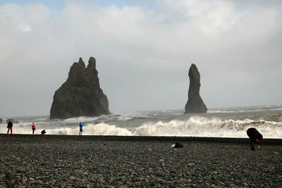 People on beach against sky