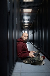 Portrait of man using mobile phone while sitting on floor