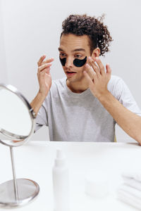 Portrait of young woman wearing sunglasses against white background