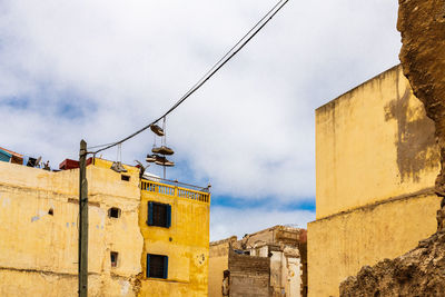 Low angle view of buildings against cloudy sky