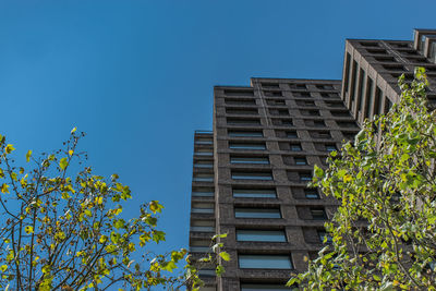 Low angle view of buildings against clear blue sky