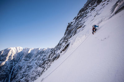 Person skiing on snowcapped mountain against sky