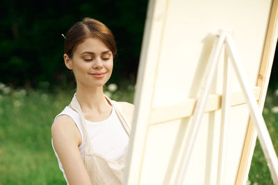 Portrait of young woman looking through window