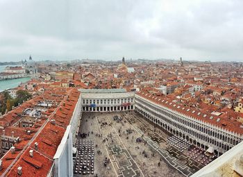 High angle view of buildings in city against cloudy sky