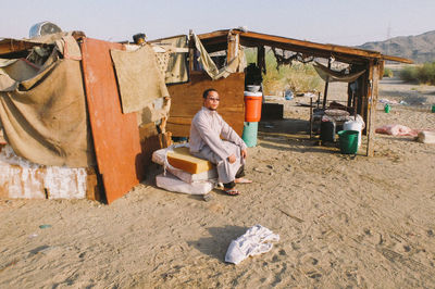 Rear view of  man sitting on desert