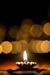 Close-up of lit candle in the dark