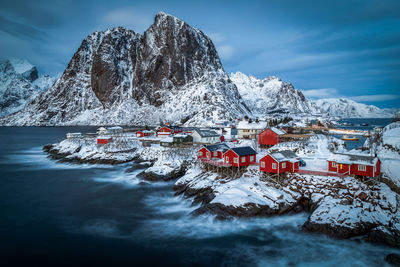 Scenic view of town against snowcapped mountain during winter