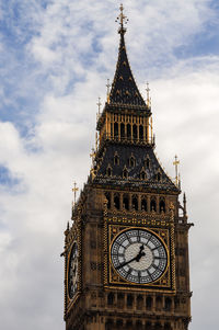 View of the top of the clock tower in london or big ben with a cloudy sky