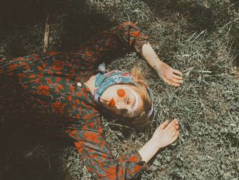 High angle view of woman with make-up lying on field