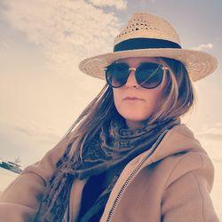 Portrait of woman wearing sunglasses against sky during winter