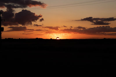 Scenic view of silhouette field against sky during sunset